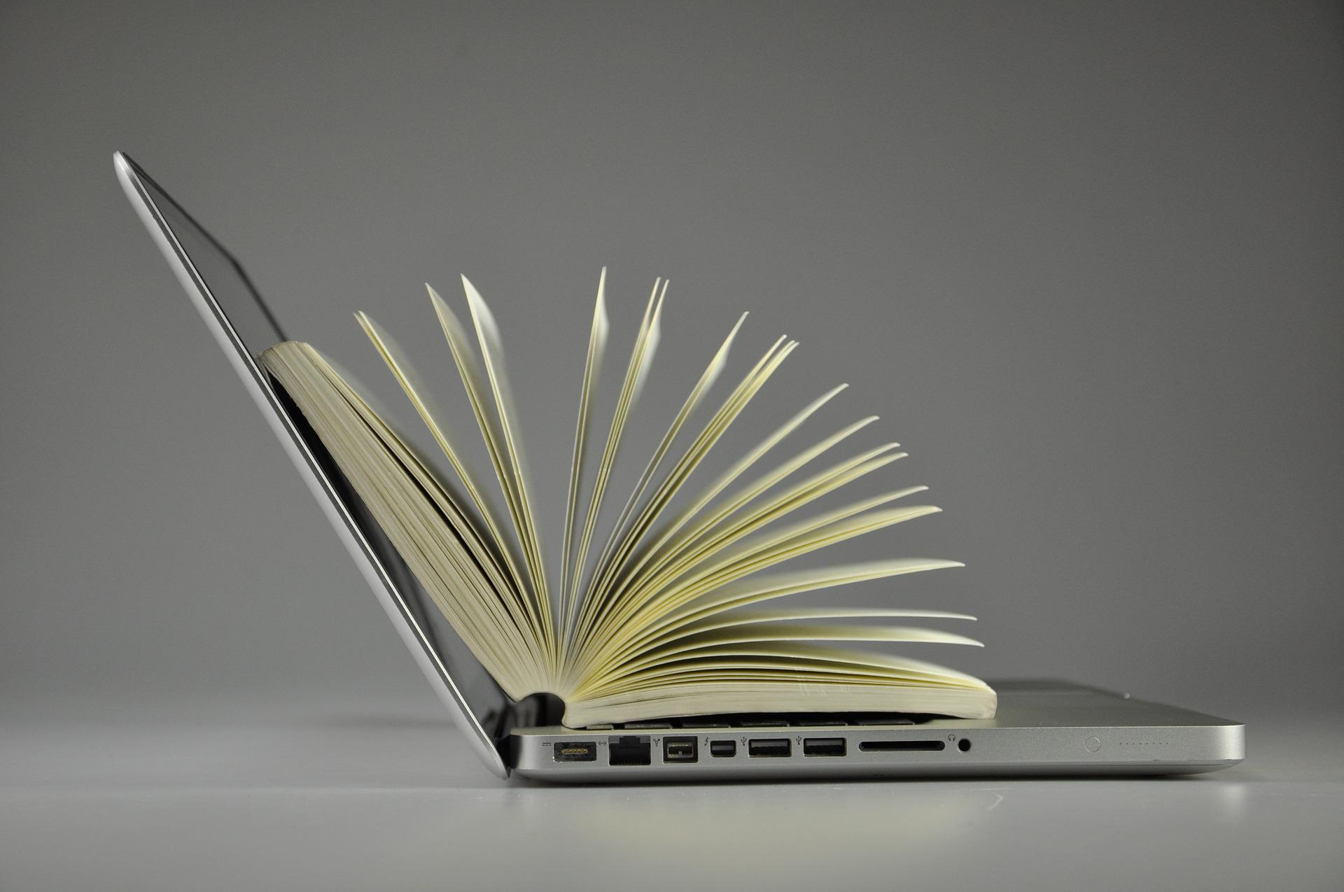 Open book above laptop 